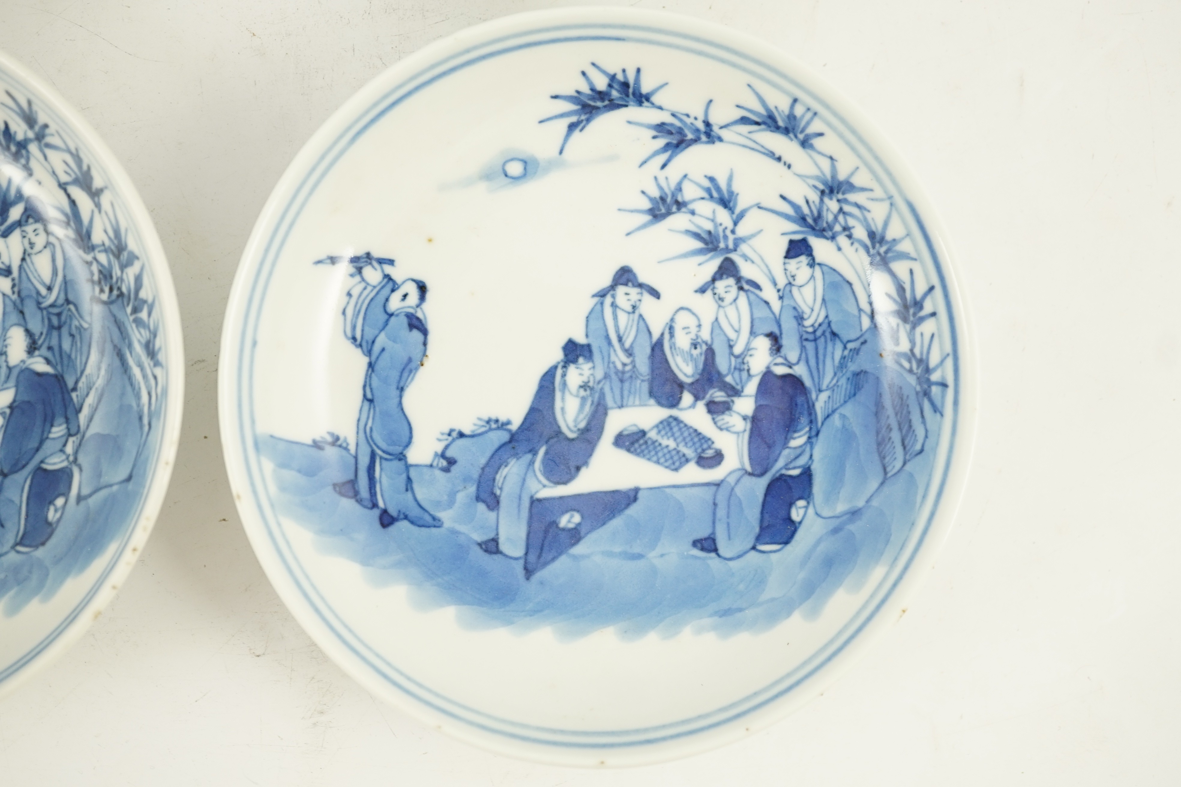 A set of six Chinese ‘Seven Sages of the Bamboo Grove’ saucer dishes, Kangxi marks but late 19th century, 12.3cm diameter